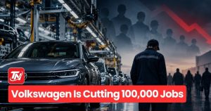 Volkswagen factory worker cleaning VW logo, symbolizing 100,000 job cuts announced in 2026